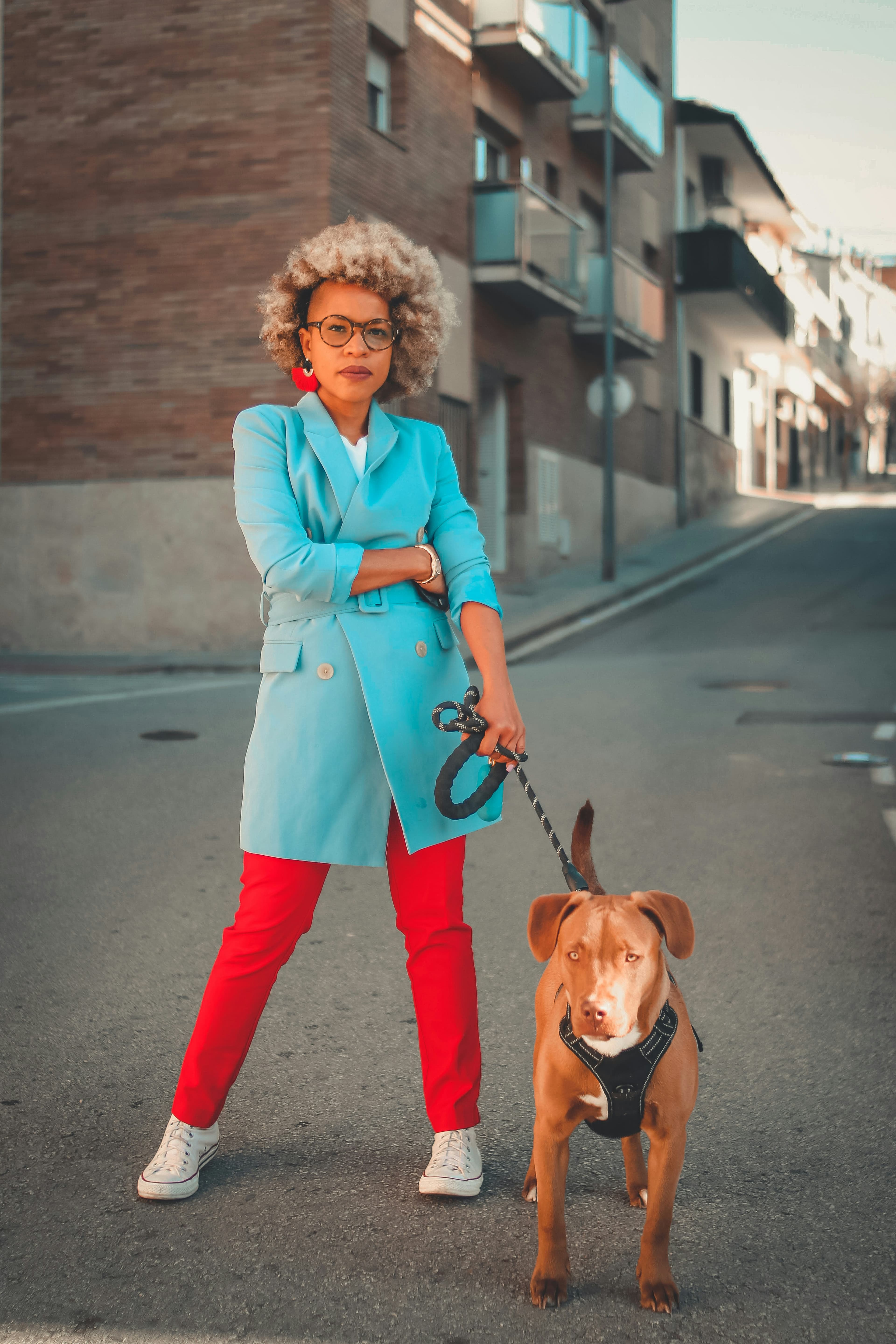 Femme qui promène son chien en laisse dans la rue